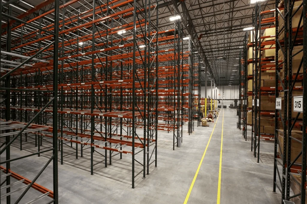 Warehouse Rows of orange and black Ridg-U-Rak pallet racks in a bright, organized warehouse.