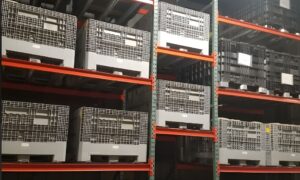 Stacked plastic containers on shelving arranged to keep aisles clear for smooth warehouse traffic