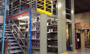Industrial mezzanine with shelving and stairs designed for heavy-duty load support