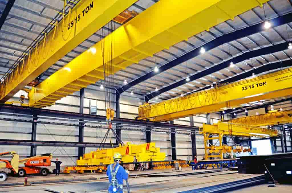 Warehouse Midwest Warehouse Solutions, Inc. crane and hoist services in action, moving equipment within a warehouse setting.