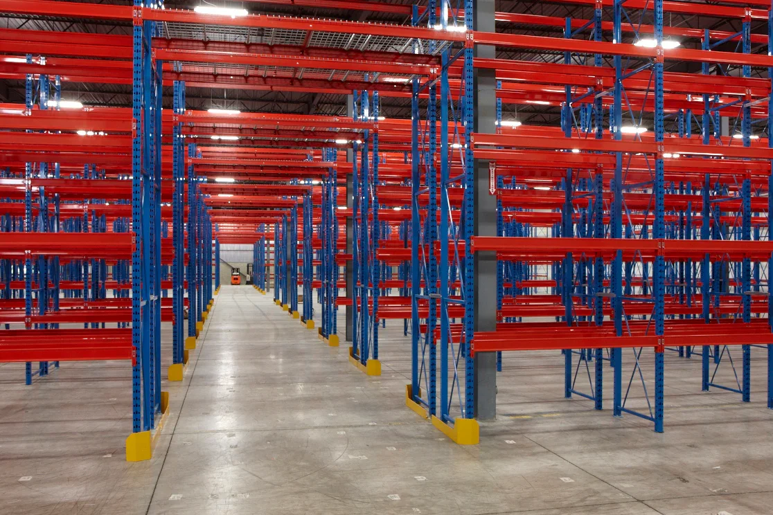 Warehouse Empty red and blue pallet racks in a spacious warehouse: Learn about versatile shelving-supported mezzanines.