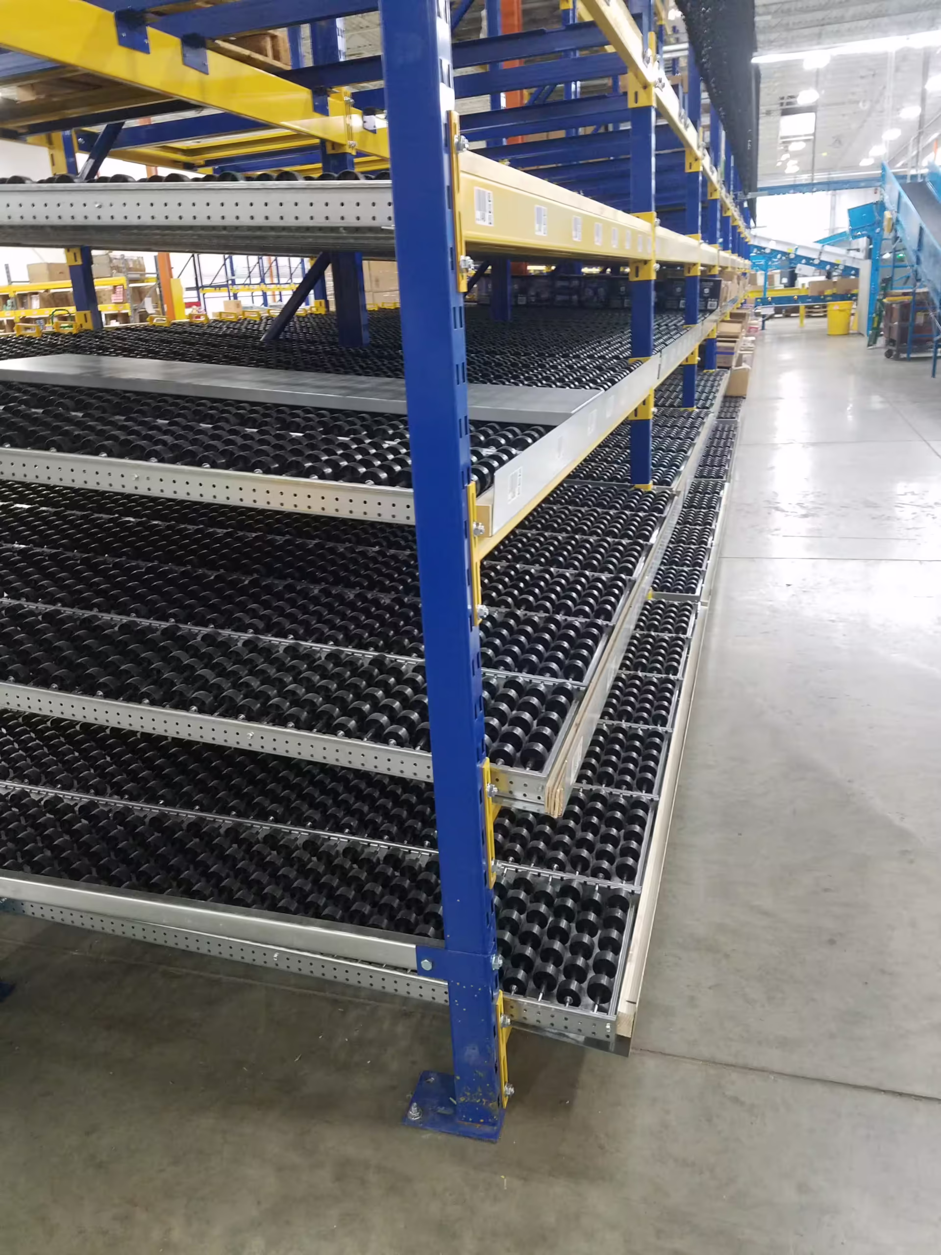 Carton flow racking with rear-loading replenishment aisle separated from pick face