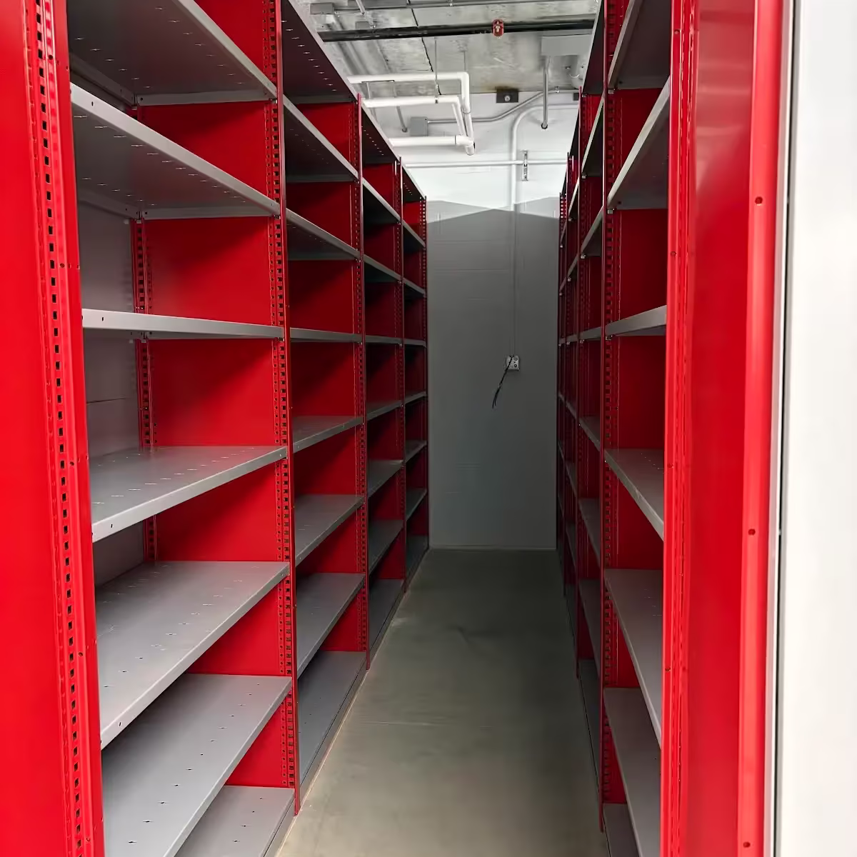 Closed industrial steel shelving aisle with adjustable multi-level shelves for warehouse parts and inventory storage