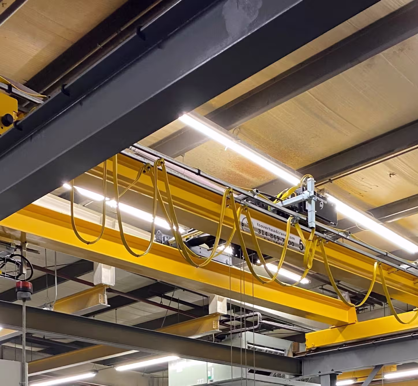 Freestanding bridge crane self-supporting system installed in manufacturing facility