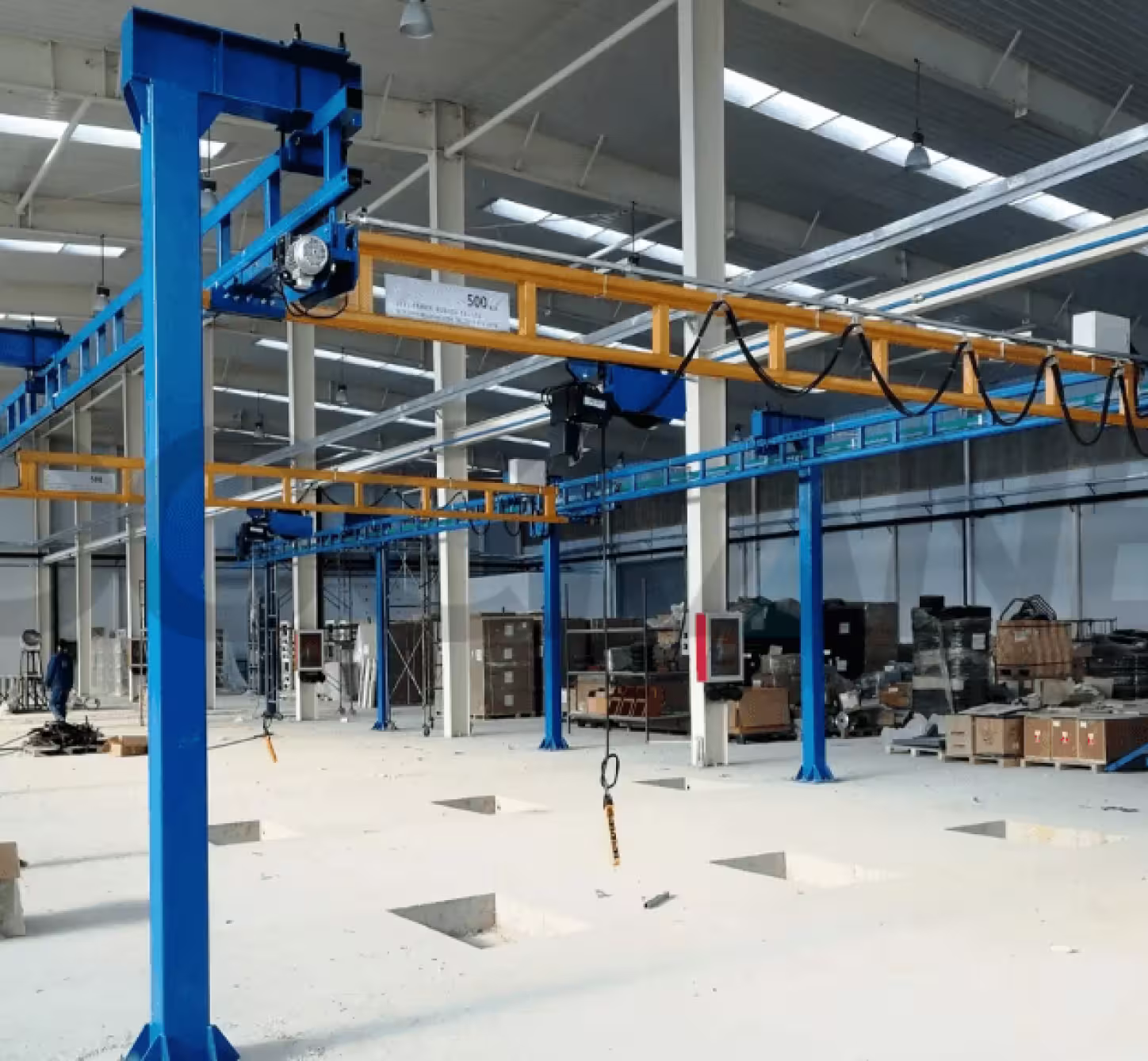 Workstation bridge crane with enclosed track design for overhead lifting coverage
