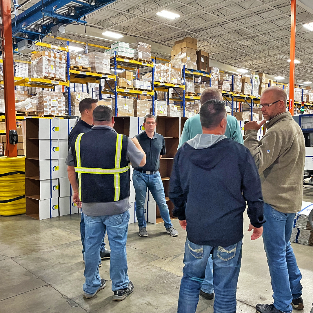 Website-Photo_service-and-support MWS consultant leading a group of clients on a warehouse site visit near loaded pallet racking